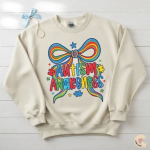 Coquette style autism awareness bow design printed on a cream-colored oversized crewneck sweatshirt with pearl accessories.