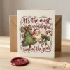 Premium Christmas greeting card mockup featuring a vintage watercolor Santa design and a red wax seal on a wooden table.
