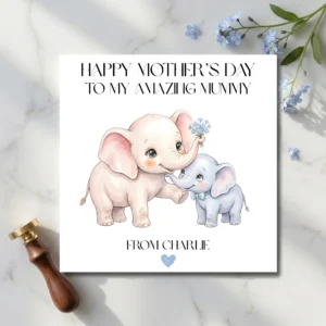 Printed square Mother's Day card with watercolor elephants lying on a marble surface next to a brass wax seal and blue forget-me-not flowers.
