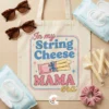 Canvas tote bag mockup with String Cheese Mama Era design surrounded by mom survival items like baby wipes, sunglasses, and string cheese.